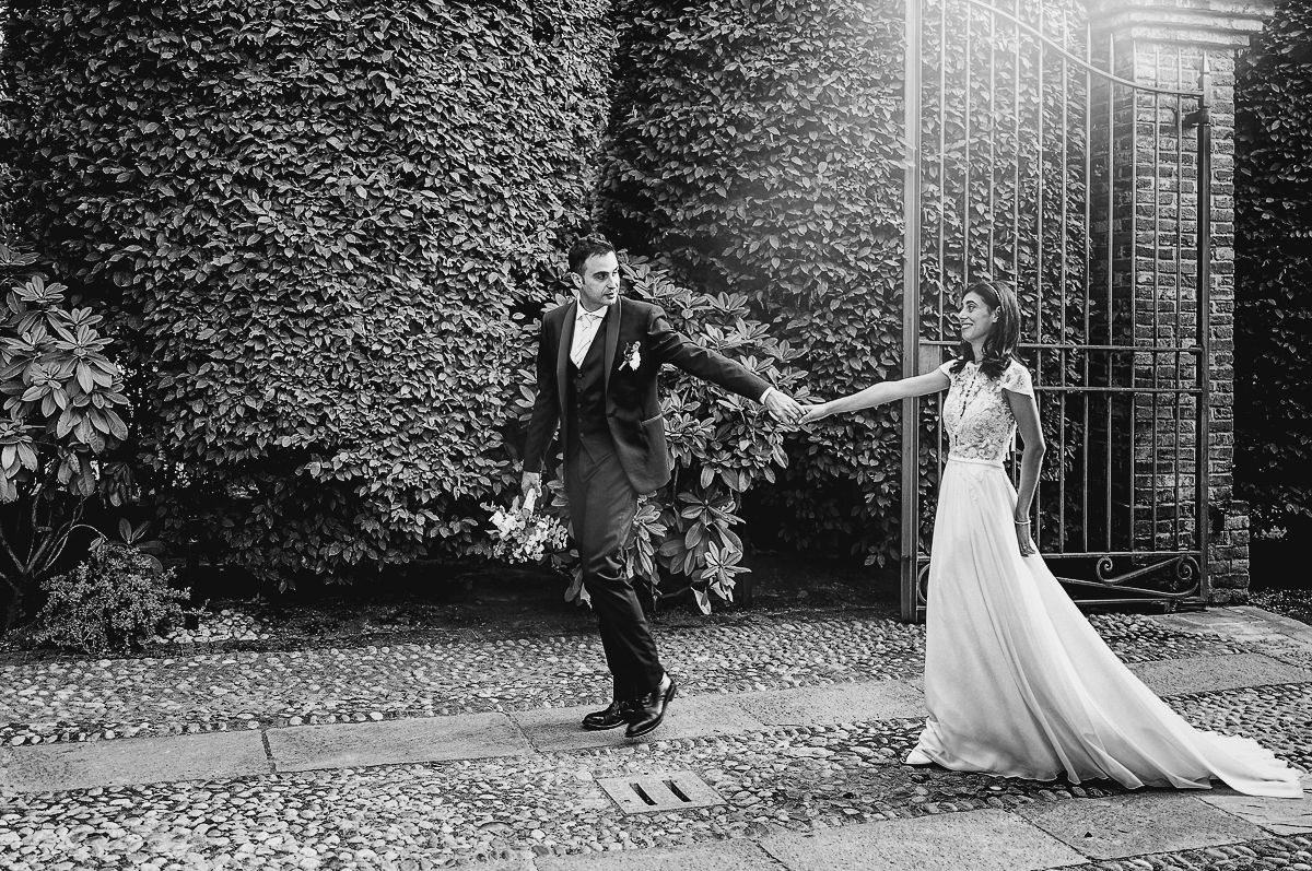 Tenuta La Cascinetta di Buriasco. Matrimonio. Sessione di coppia al tramonto lungo il viale di cipressi. Sposi camminano verso la zona dell'aperitivo.