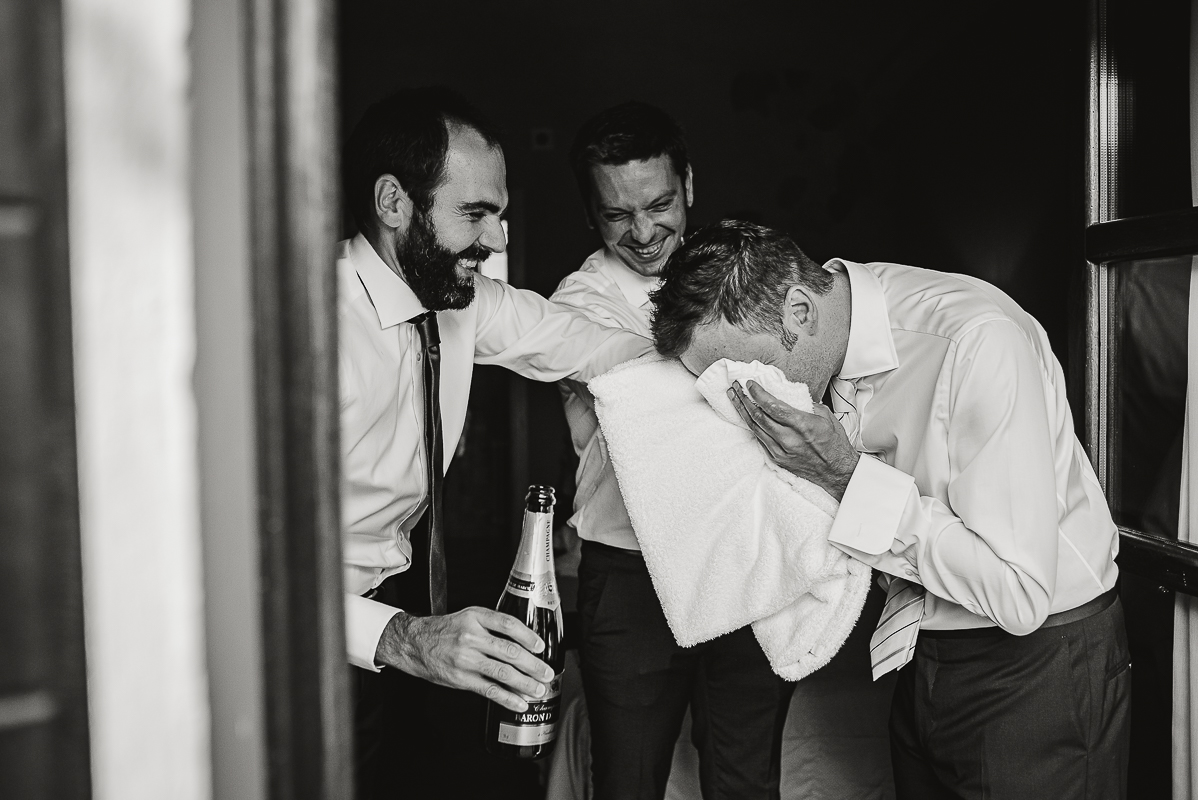 Tenuta La Cascinetta di Buriasco. Matrimonio. Preparazione dello sposo. Sposo si asciuga il viso con un asciugamano.