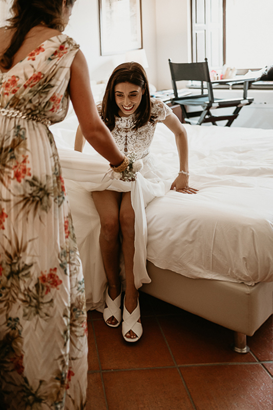 Tenuta La Cascinetta di Buriasco. Matrimonio. Preparazione della sposa. Sposa si alza dal letto dopo aver indossato le scarpe.