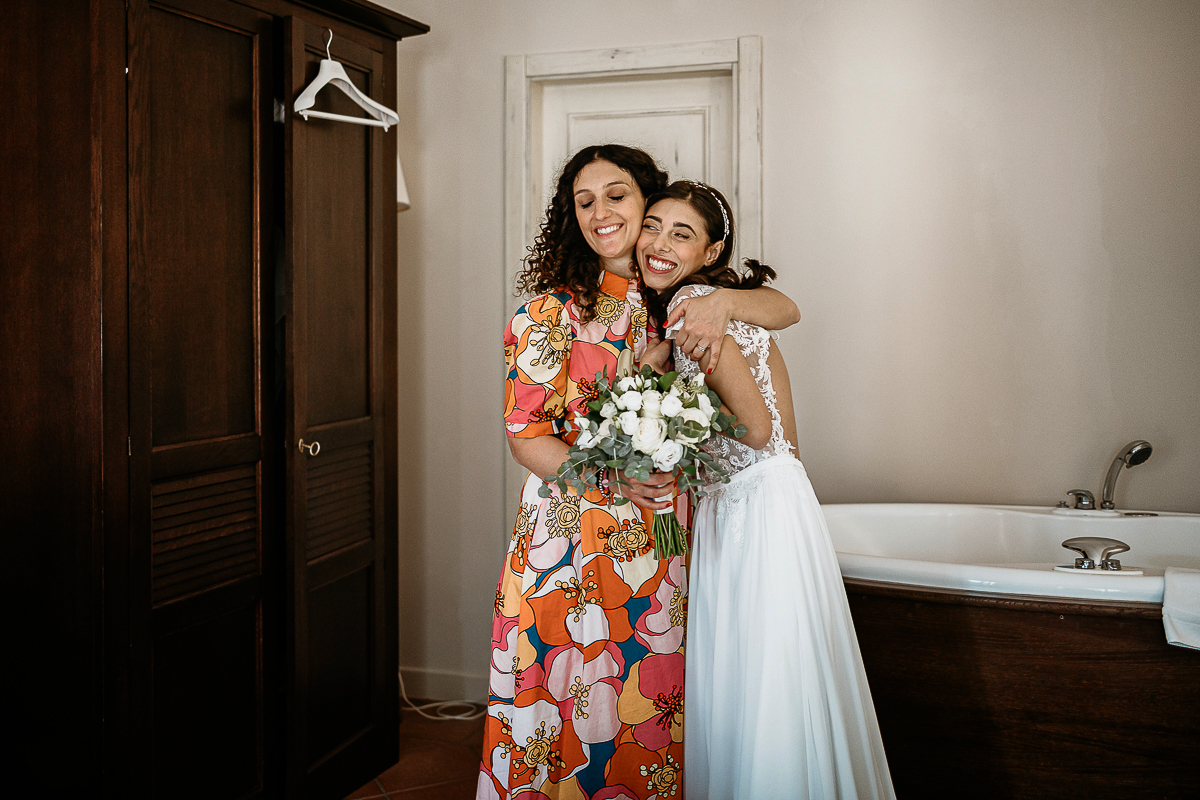 Tenuta La Cascinetta di Buriasco. Matrimonio. Preparazione della sposa. Wedding planner abbraccia la sposa.