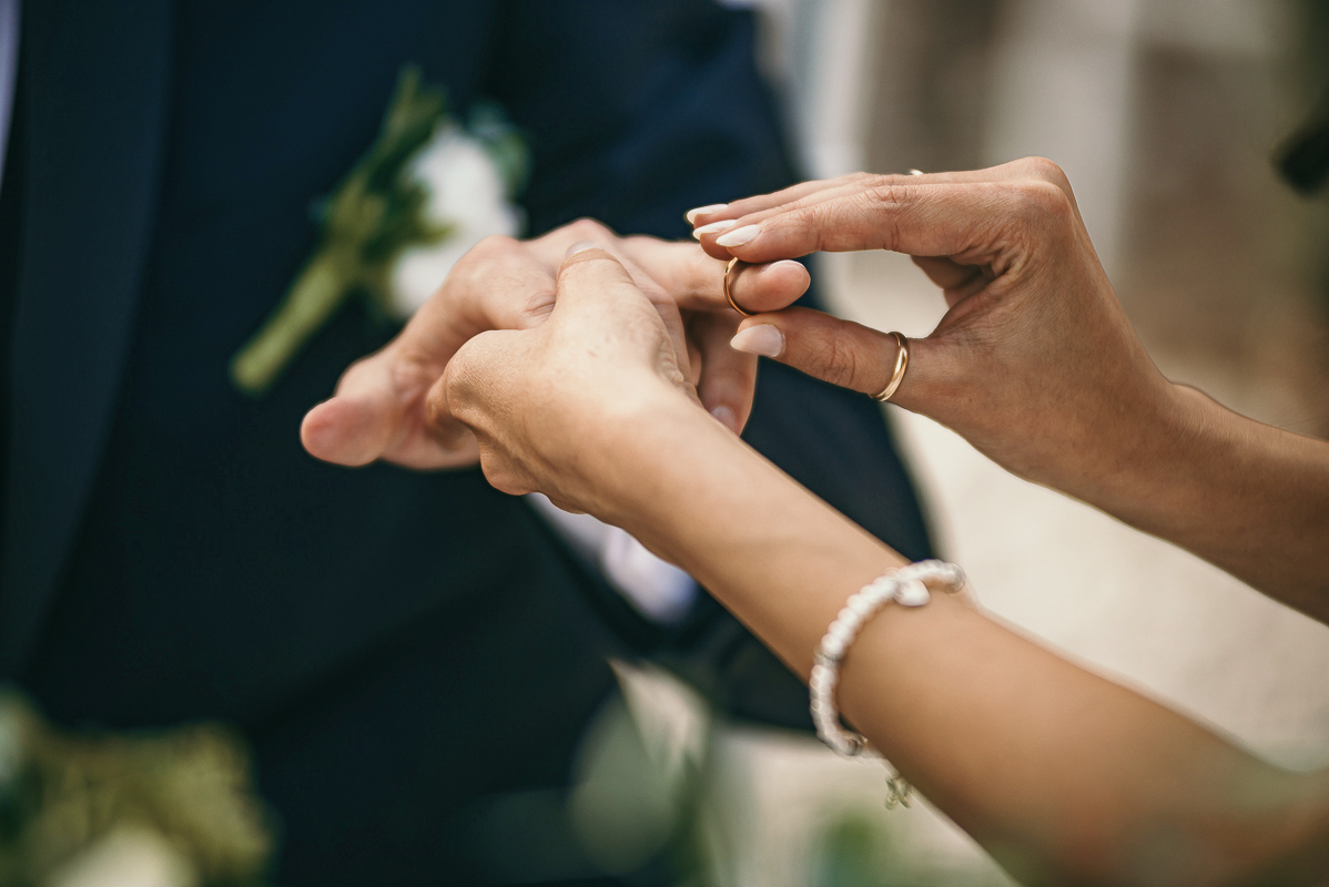 Tenuta La Cascinetta di Buriasco. Matrimonio. Cerimonia. sposa mette l'anello al dito dello sposo dettaglio.
