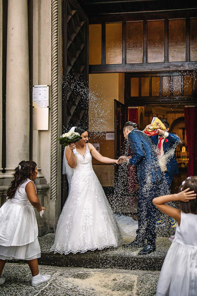 Matrimonio a Torino, chiesa di San Gioacchino. Cerimonia.Uscita degli sposi. Lancio del riso. Amico svuota un intero pacco di riso sulla testa dello sposo.