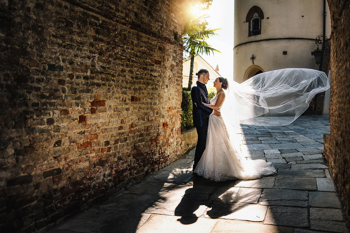 Castello di Cortanze, marrimonio , aperitivo. Foto degli sposi controluce. Velo che vola.