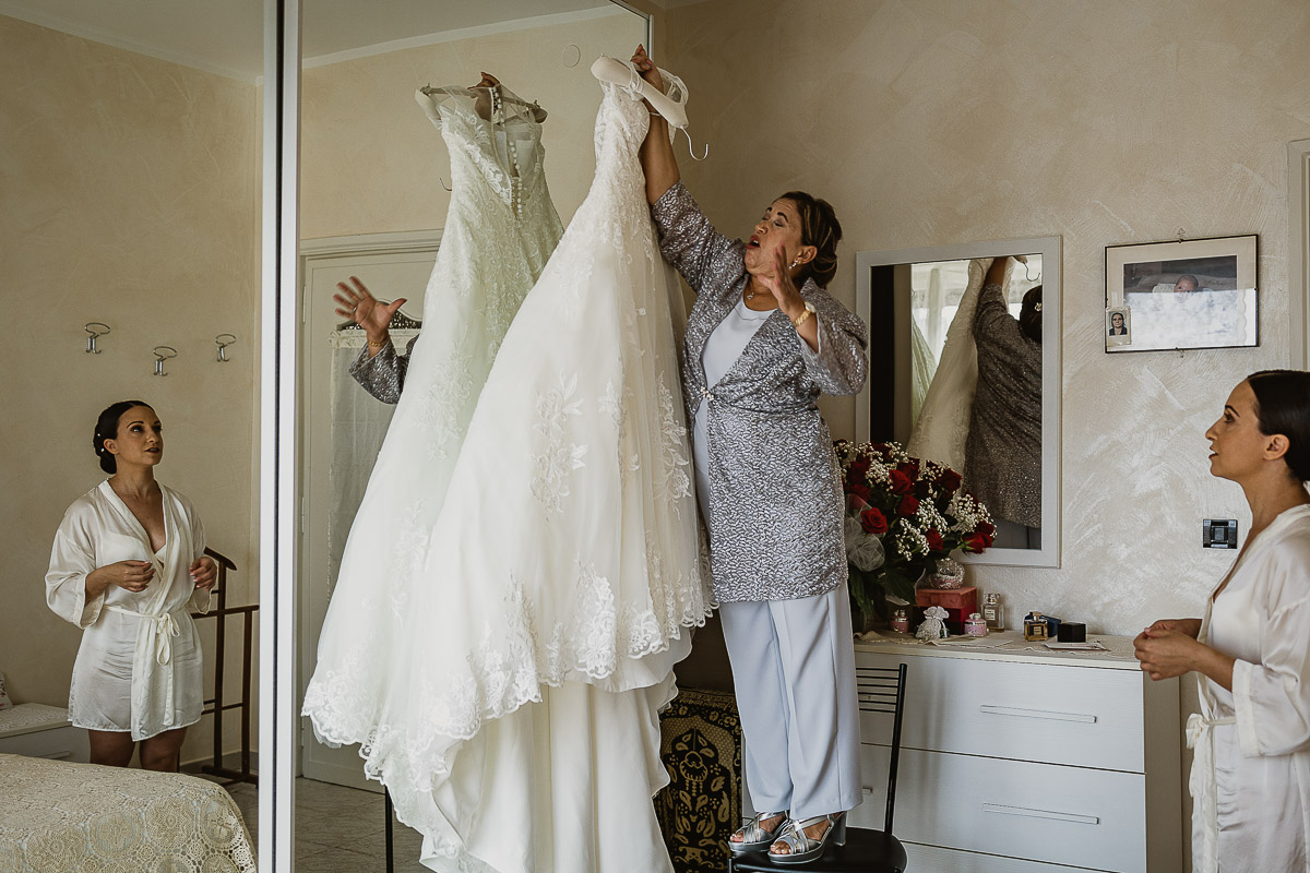 Matrimonio a Torino, preparazione della sposa, madre prende l'abito della sposa.