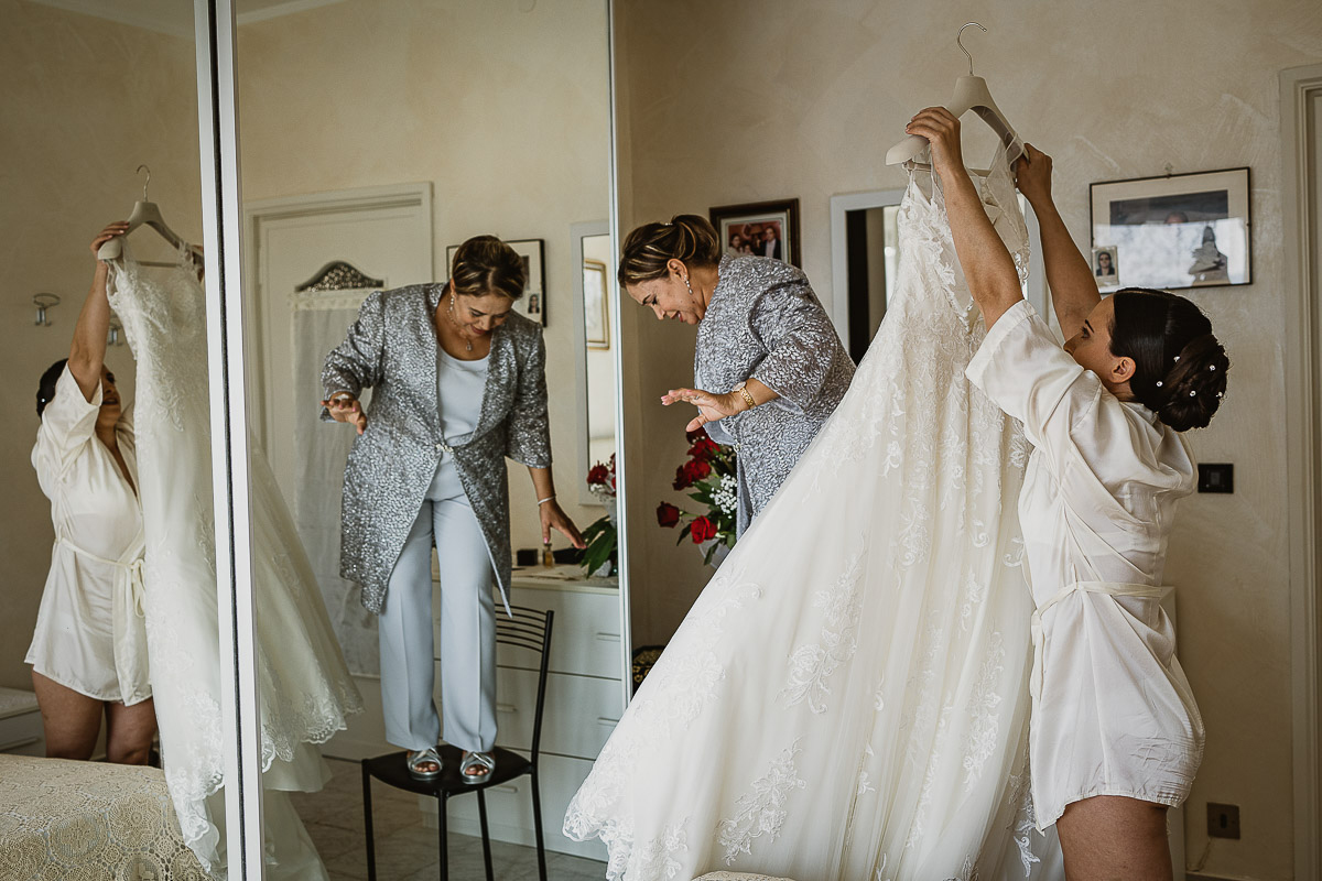 Matrimonio a Torino, preparazione della sposa, sposa tiene in mano il suo abito.