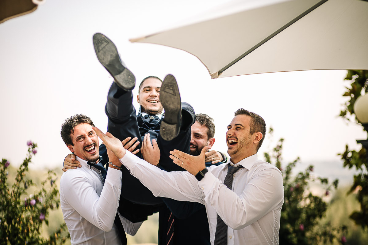 Castello di Cortanze, matrimonio. Aperitivo. Sposo con gli amici che lo prendono in braccio.