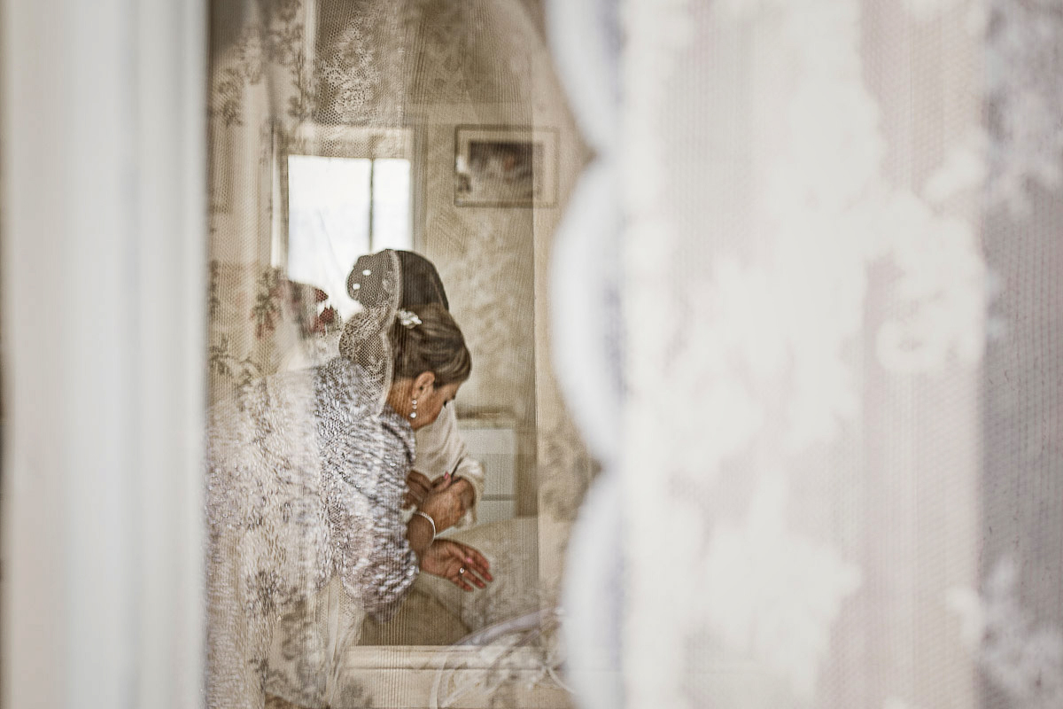Matrimonio a Torino, preparazione della sposa, sposa e madre riprese attraverso una tenda di pizzo.
