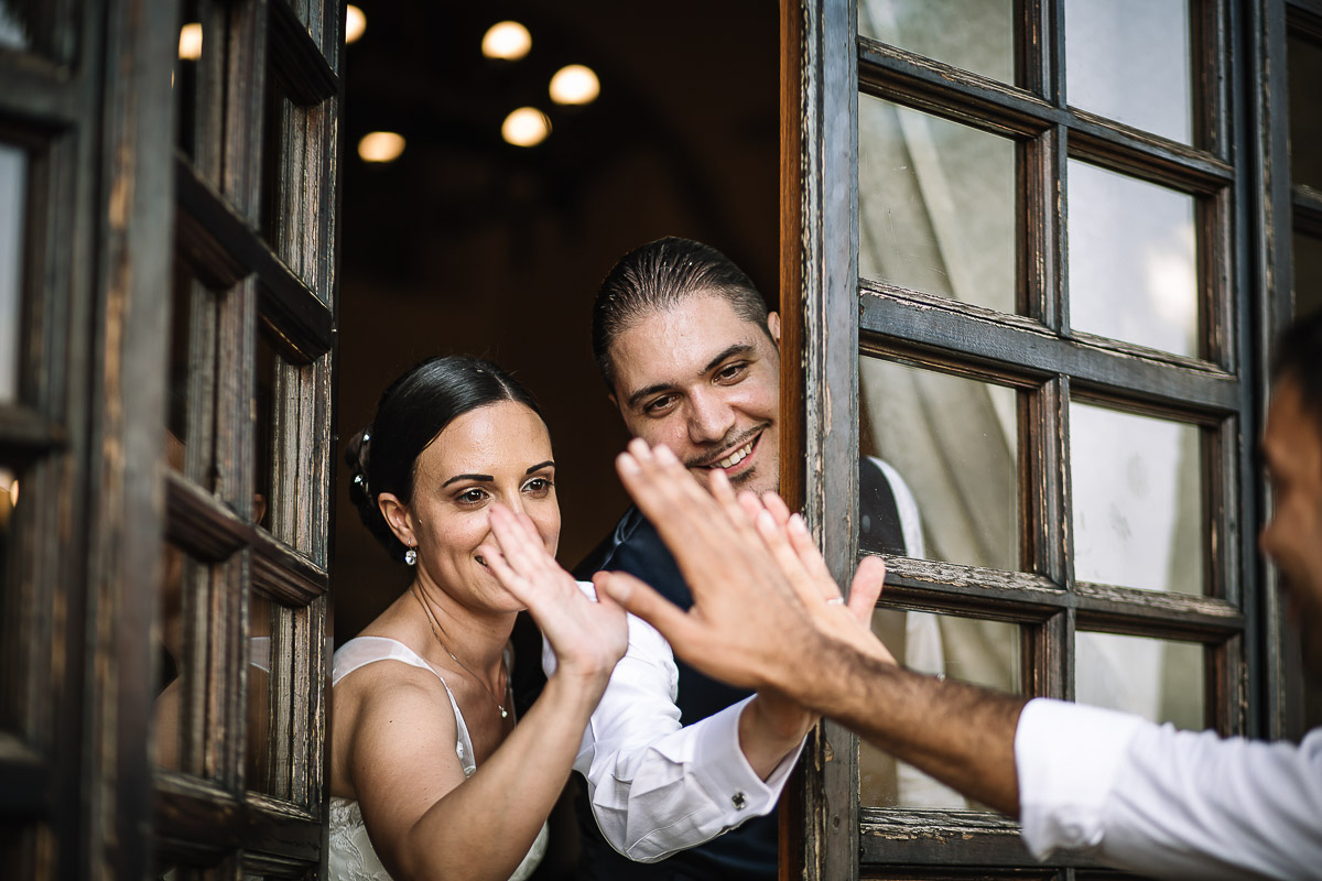 Castello di Cortanze, matrimonio. Ricevimento. Sposi salutano gli amici dalla finestra.