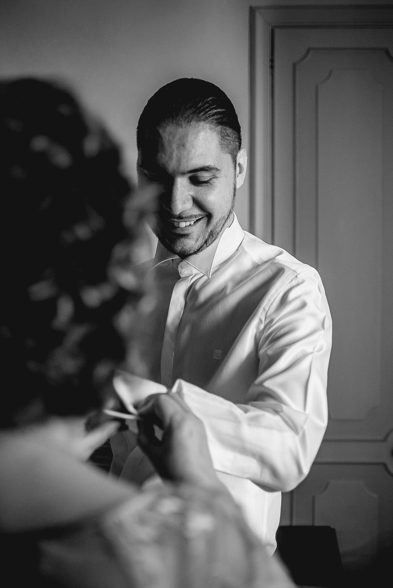 Matrimonio a Torino, preparazione dello sposo. mamma abbottona il polsino della camicia dello sposo.