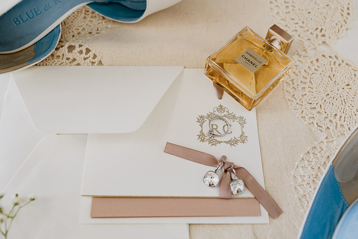 Matrimonio a Torino, preparazione della sposa, orecchini,anello di fidanzamento e profumo sulla partecipazione.