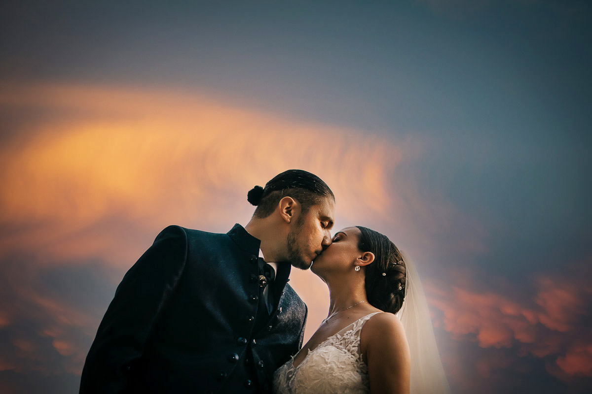 Castello di Cortanze, matrimonio. Ricevimento.Foto di coppia al tramonto. Sposi che si baciano