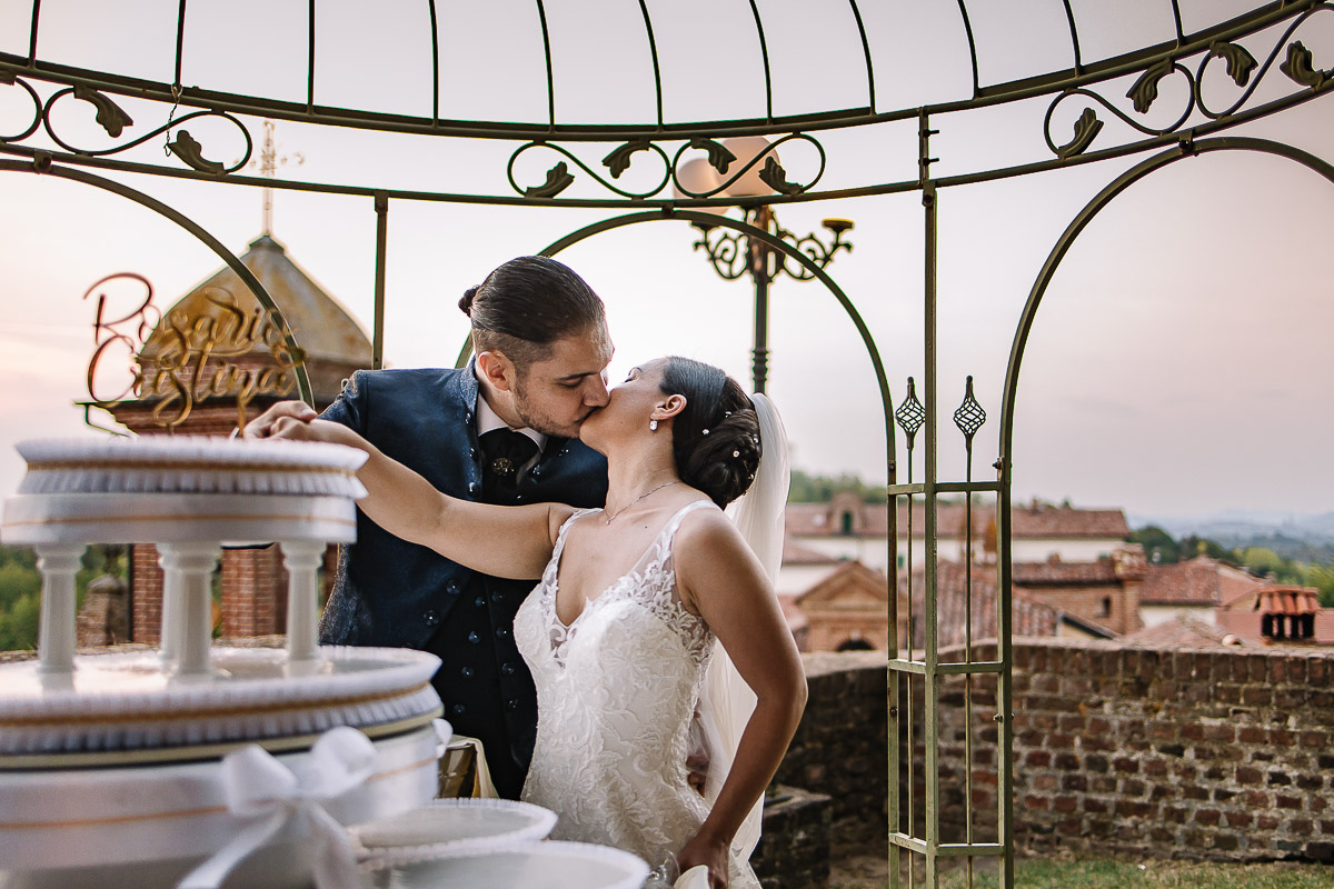 Castello di Cortanze, matrimonio. Ricevimento.Foto di coppia al tramonto. Taglio della torta. Bacio