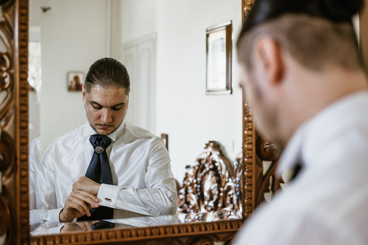 Matrimonio a Torino, preparazione dello sposo.Sposo riflesso allo specchio con il polsino e i gemelli della camicia.