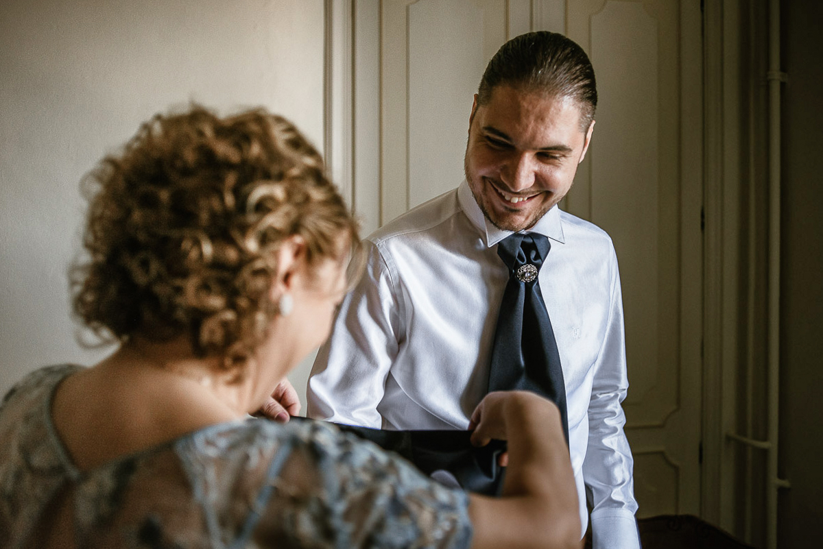 Matrimonio a Torino, preparazione dello sposo.mamma aiuta lo sposo ad indossare la giacca,