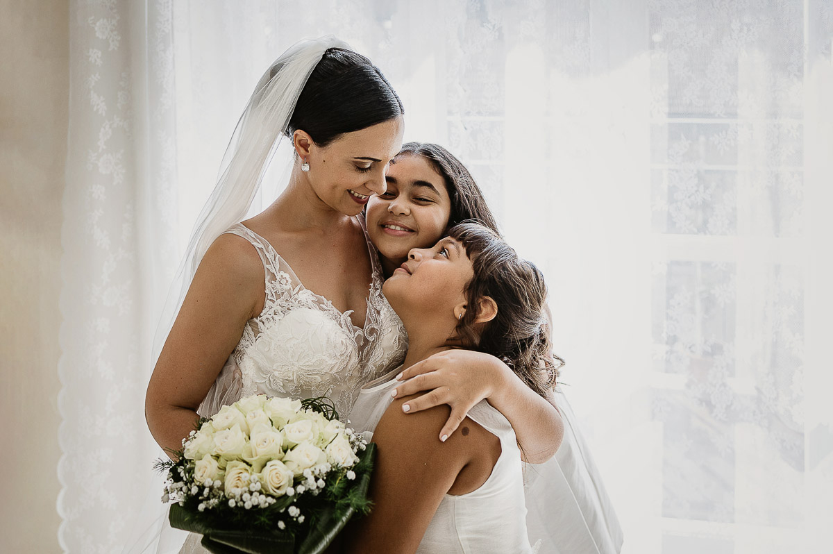 Matrimonio a Torino, preparazione della sposa, sposa abbraccia le sorelline.
