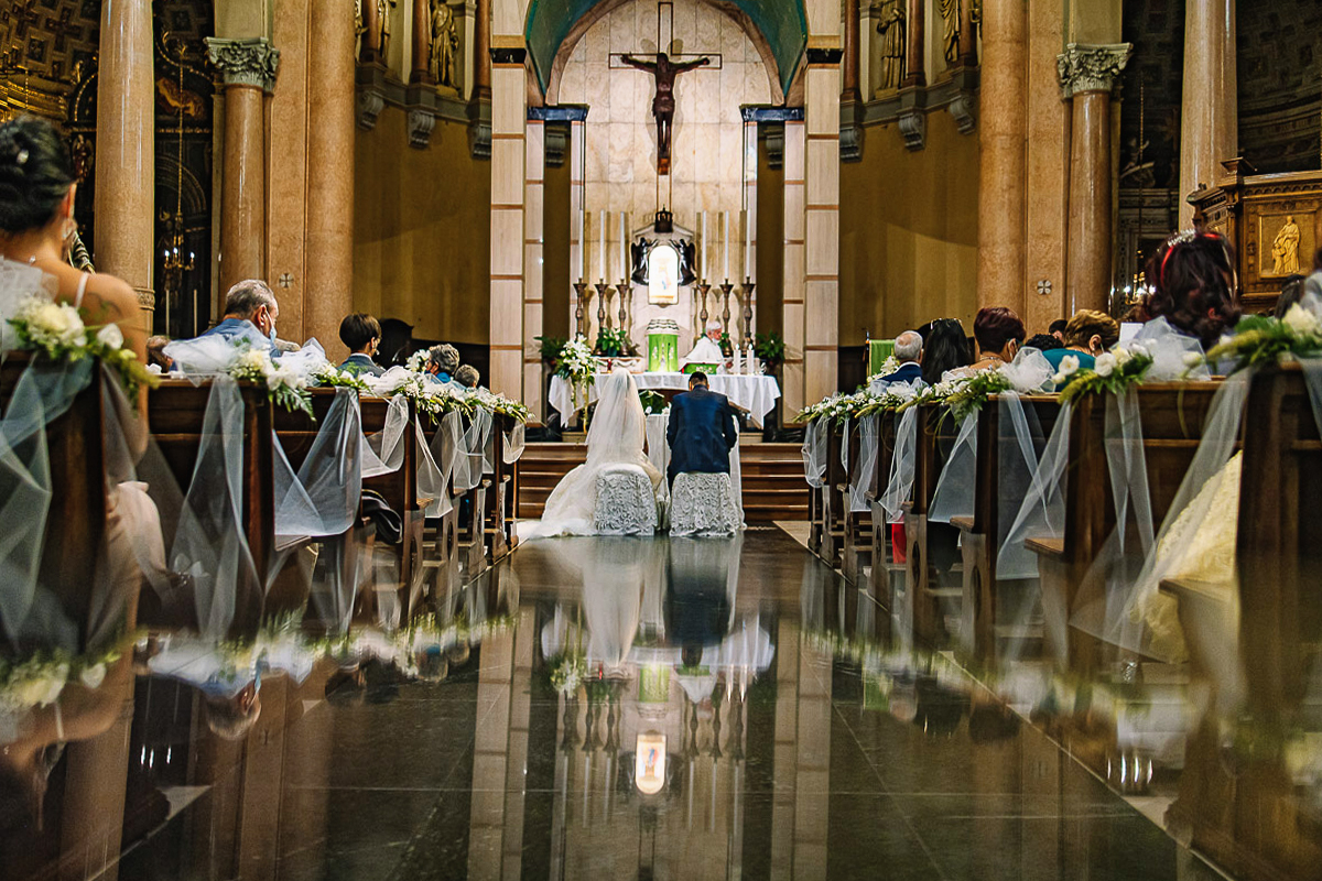 Matrimonio a Torino, chiesa di San Gioacchino. Cerimonia. Sposi ed invitati da dietro riflessi in uno specchio.