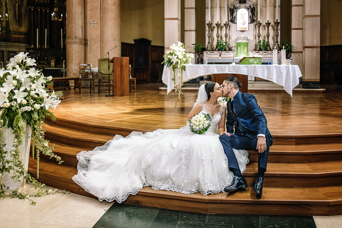 Matrimonio a Torino, chiesa di San Gioacchino. Cerimonia. Sposi si baciano seduti sulle scale dell'altare.