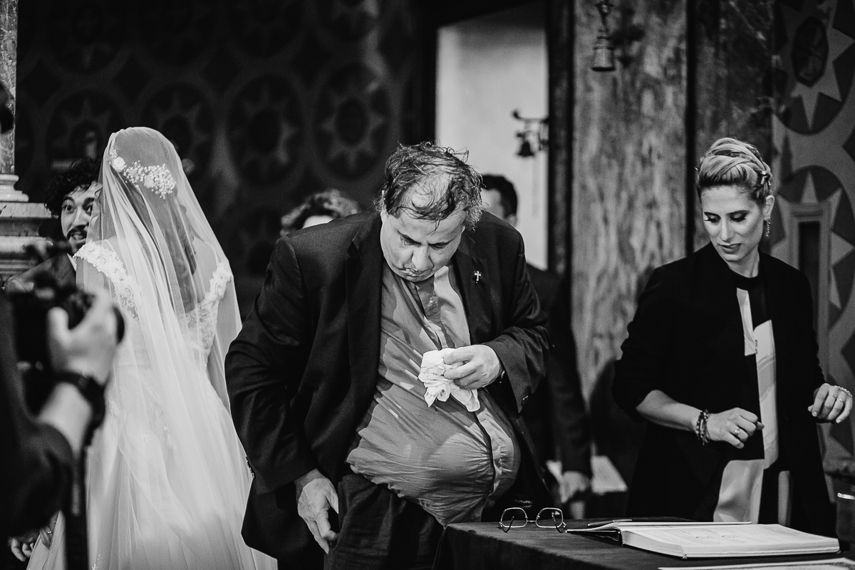 Matrimonio a Torino, cerimonia chiesa dei Santi Angeli Custodi. messa. sacerdote corpulento si asciuga il sudore con un fazzoletto.