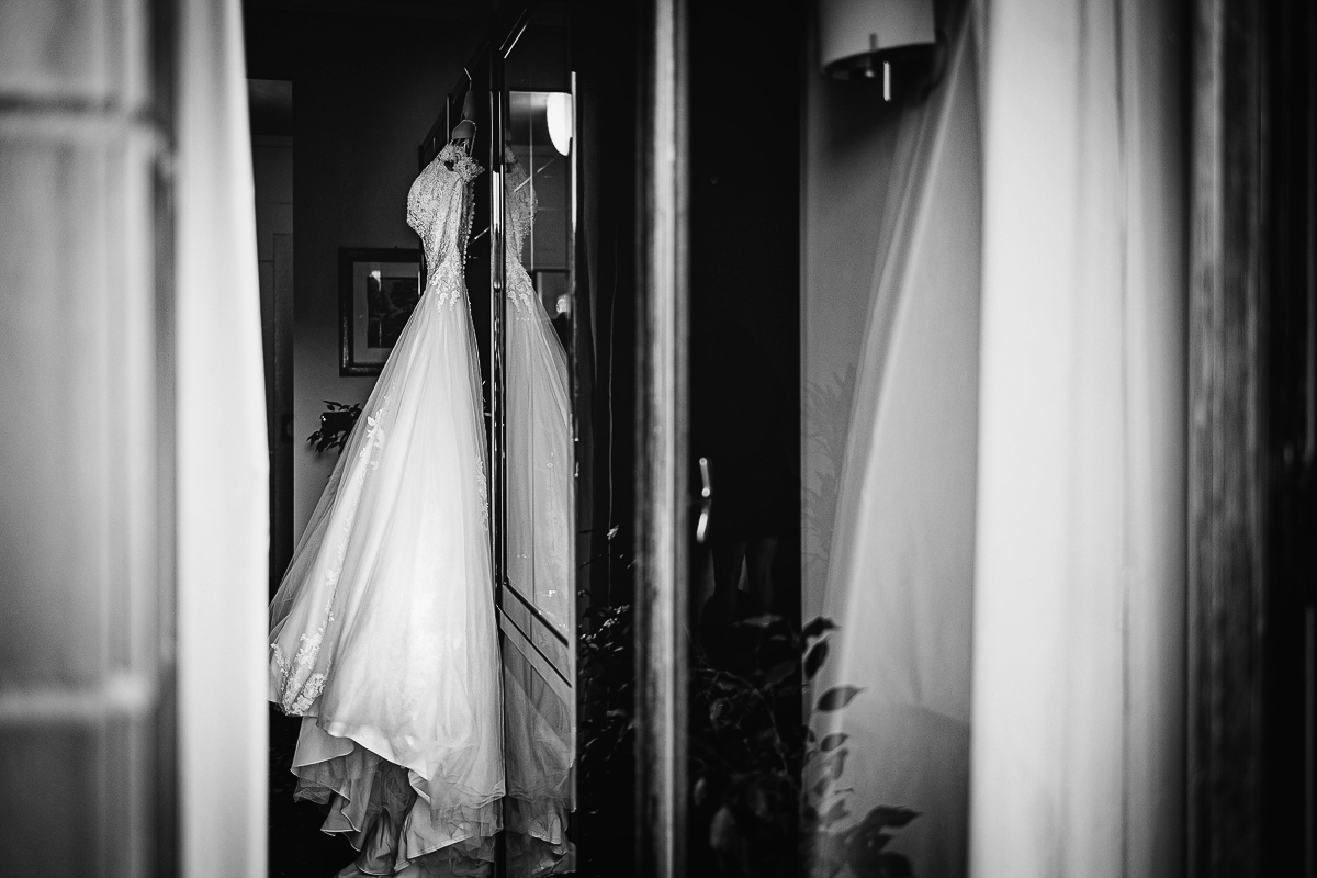 Matrimonio a Torino, preparazione della sposa.Abito appeso riflesso nel vetro della porta finestra