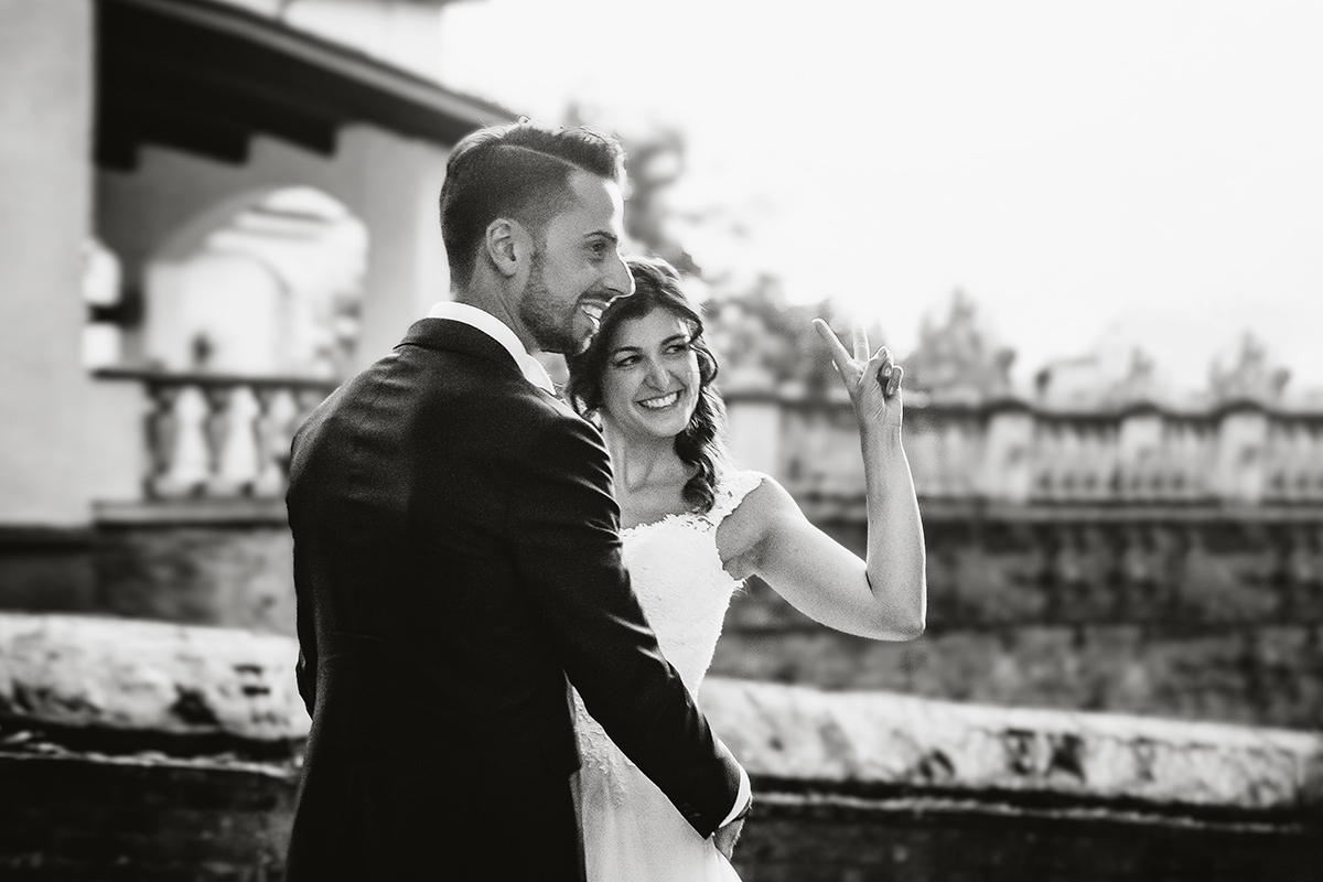 matrimonio al Castello di Oviglio. Aperitivo. Sessione di coppia degli sposi nel giardino del castello. Sposa saluta.