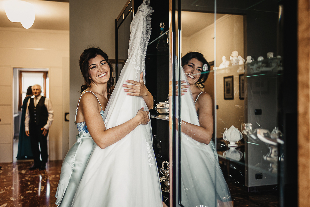 Matrimonio a Torino, preparazione della sposa. Sposa stringe il suo abito.