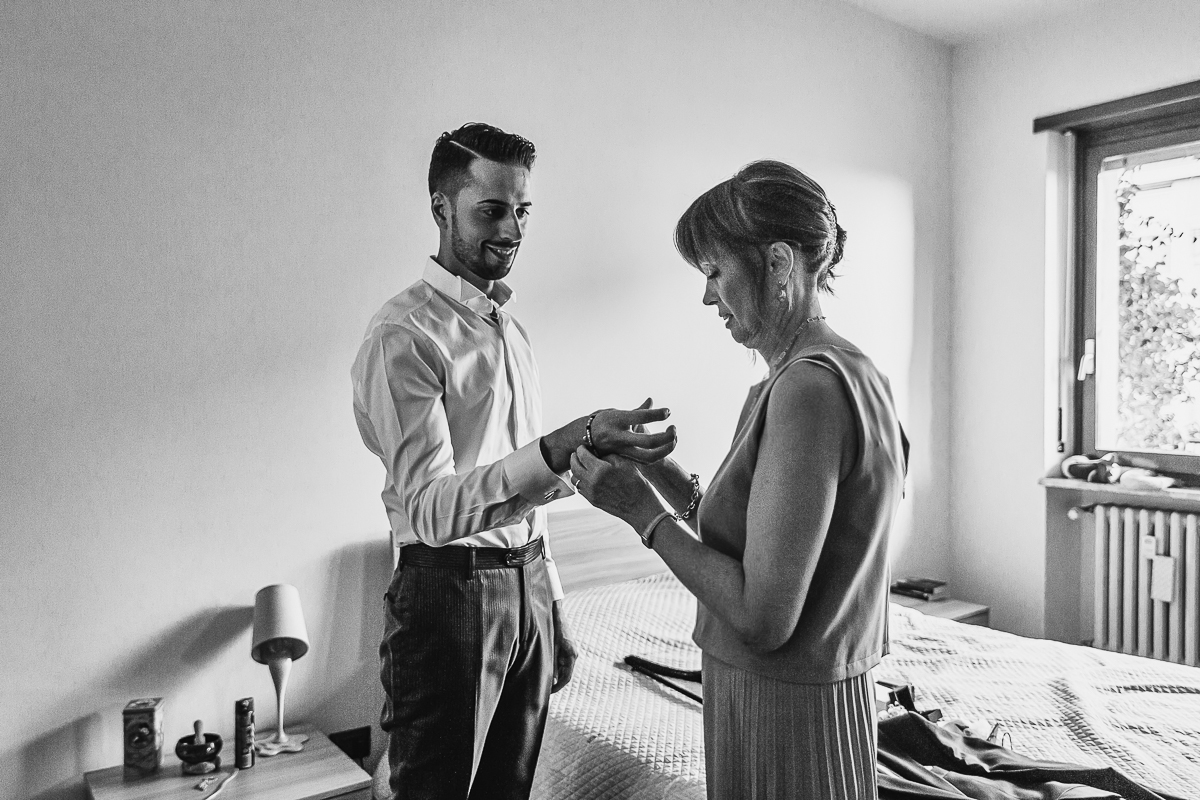 Matrimonio a Torino, preparazione dello sposo. mamma aiuta lo sposo a vestirsi.