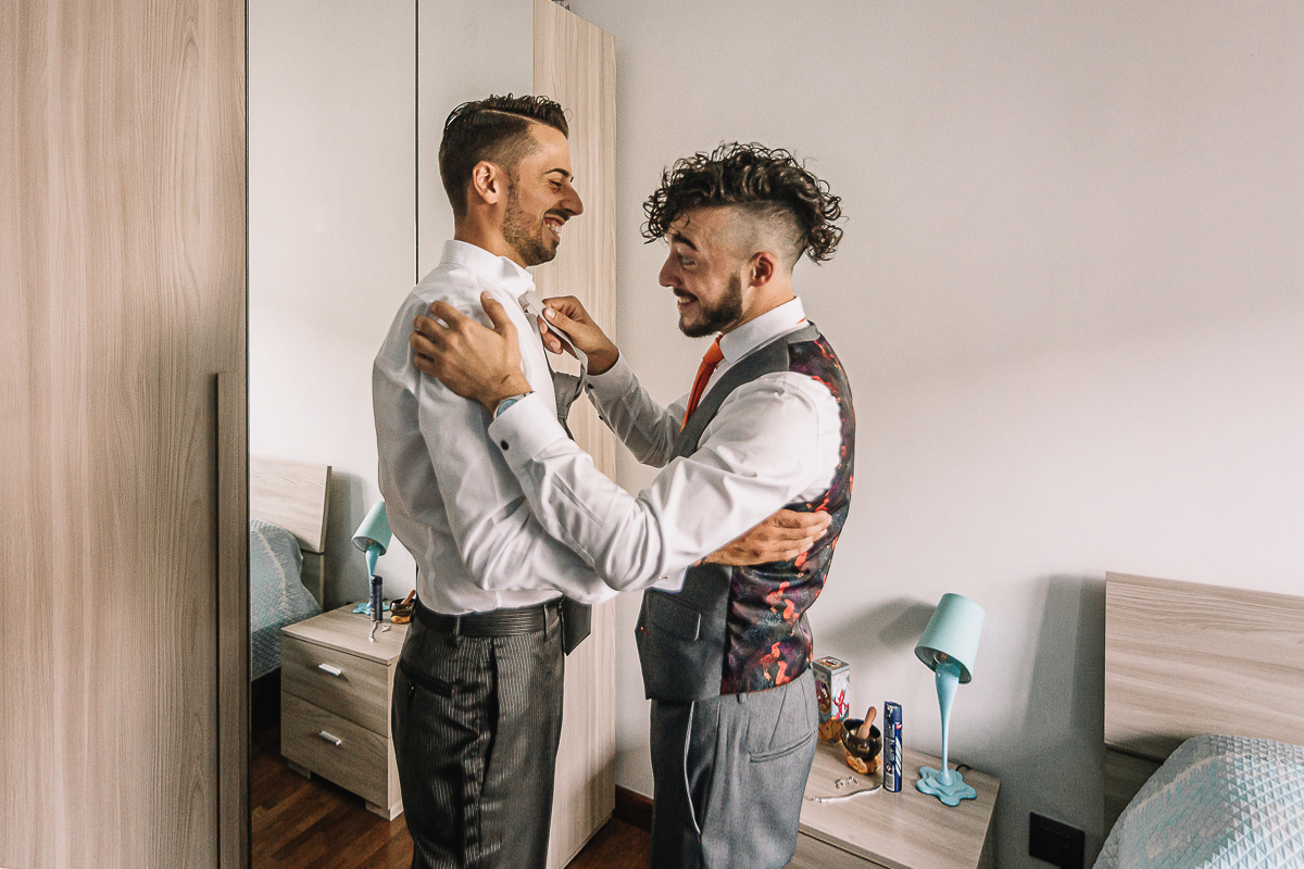 Matrimonio a Torino, preparazione dello sposo. Testimone aiuta lo sposo nella vestizione.