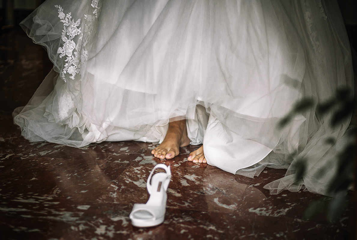 Matrimonio a Torino, preparazione della sposa. Sposa a piedi nudi. Sta per indossare le scarpe.