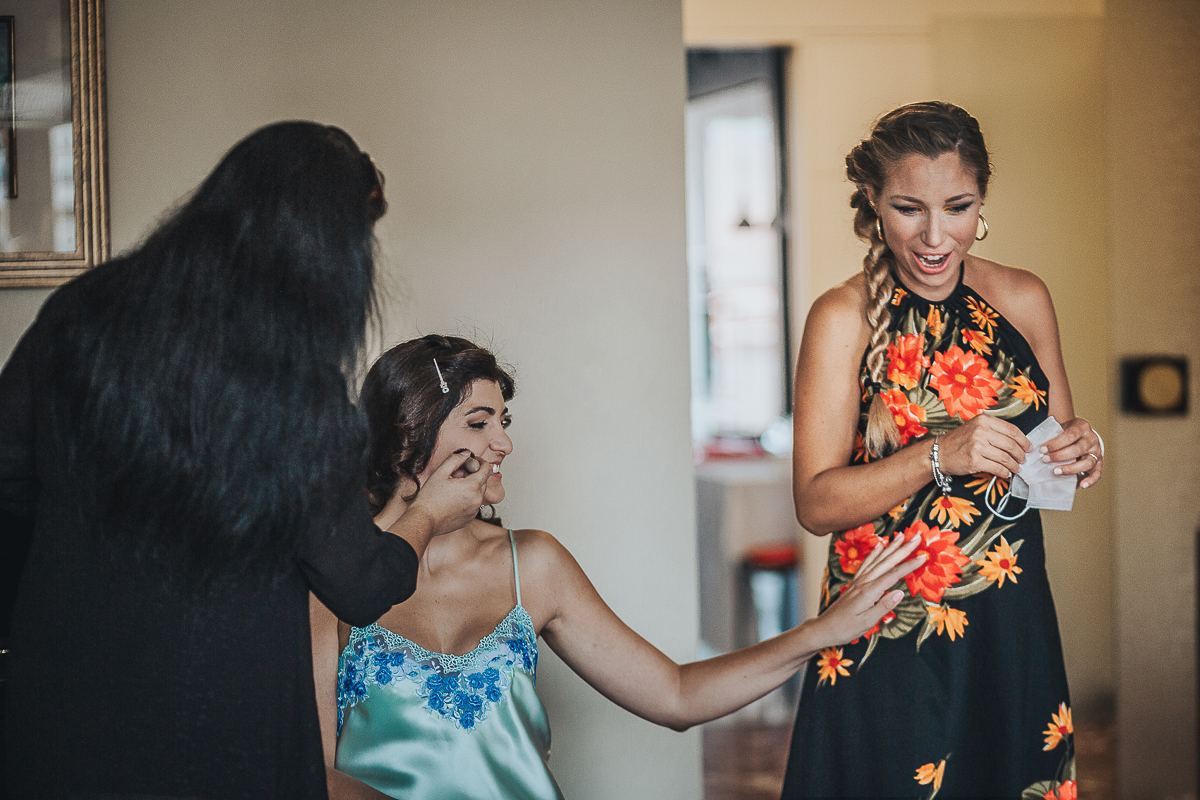 Matrimonio a Torino, preparazione della sposa. Sposa al trucco tocca il pancione all'amica in dolce attesa.