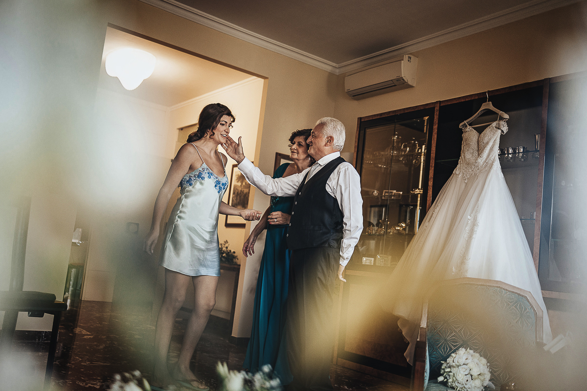 Matrimonio a Torino, preparazione della sposa. Sposa con i genitori. Padre accarezza la sposa.