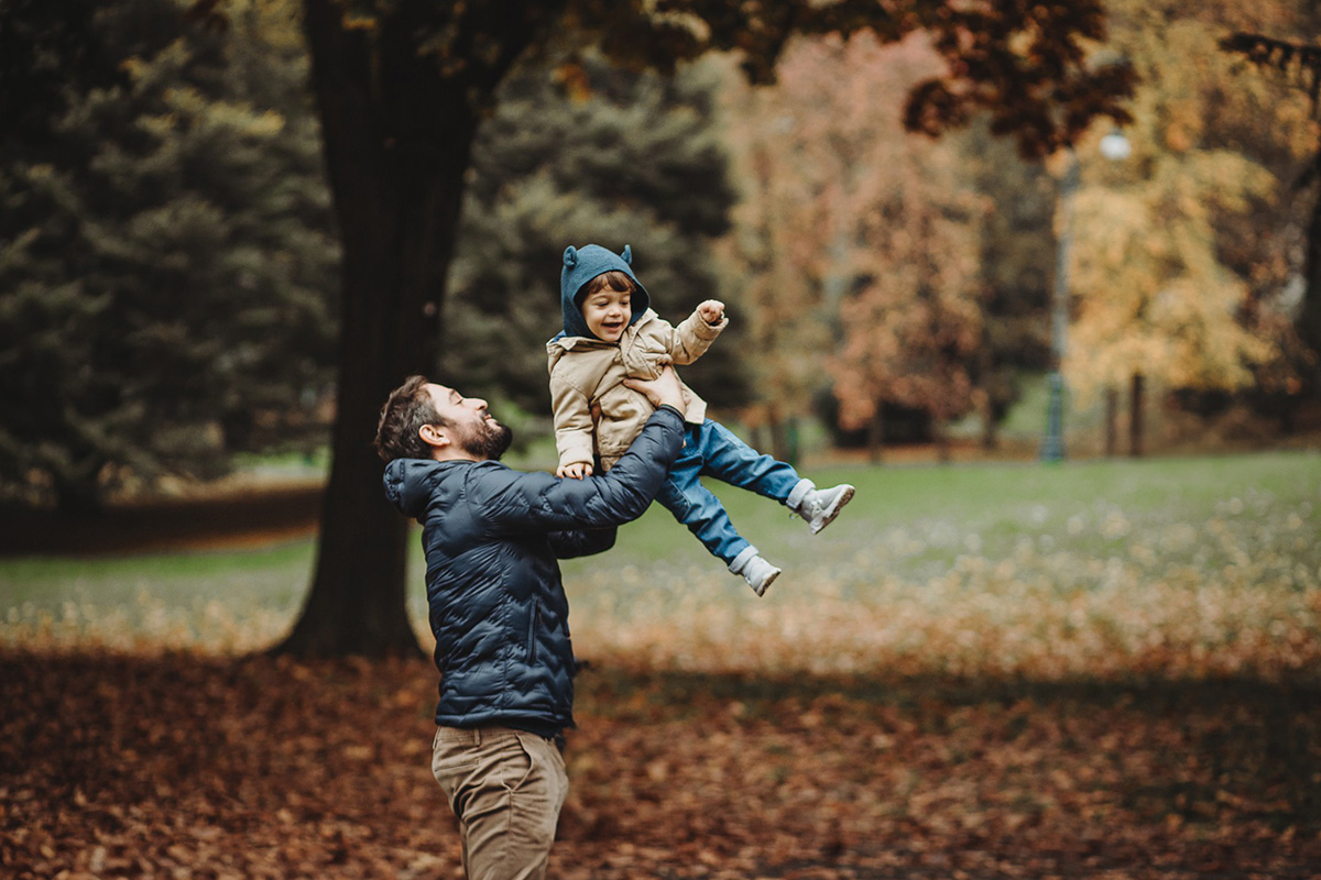 Parco del Valentino, fotografia di famiglia. Sessione fotografica autunnale. papà fa volare il bambino.