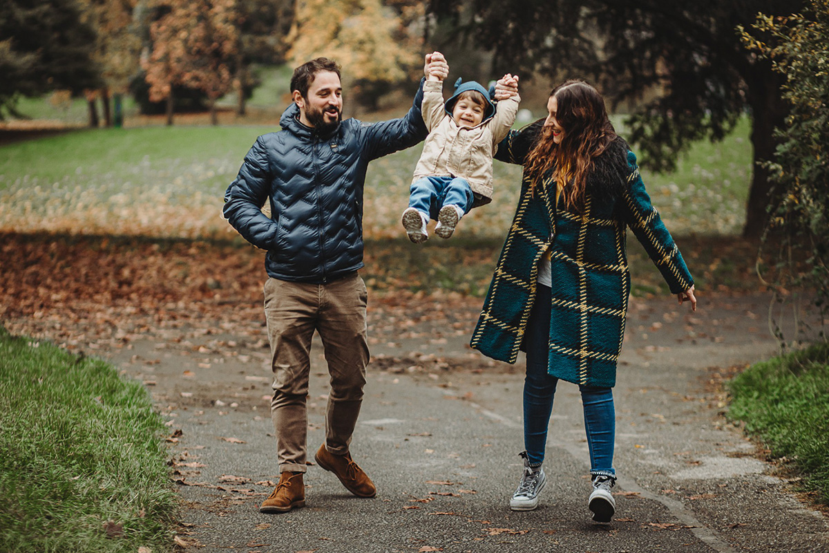 Parco del Valentino, fotografia di famiglia. Sessione fotografica autunnale. mamma e papà fanno volare il bambino