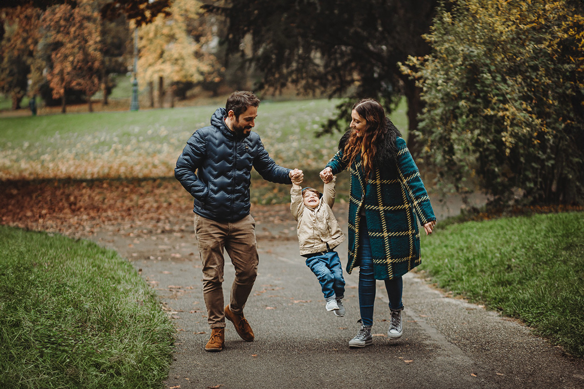 Parco del Valentino, fotografia di famiglia. Sessione fotografica autunnale. mamma e papà fanno volare il bambino