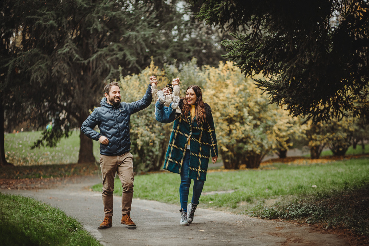 Parco del Valentino, fotografia di famiglia. Sessione fotografica autunnale. mamma e papà fanno volare il bambino
