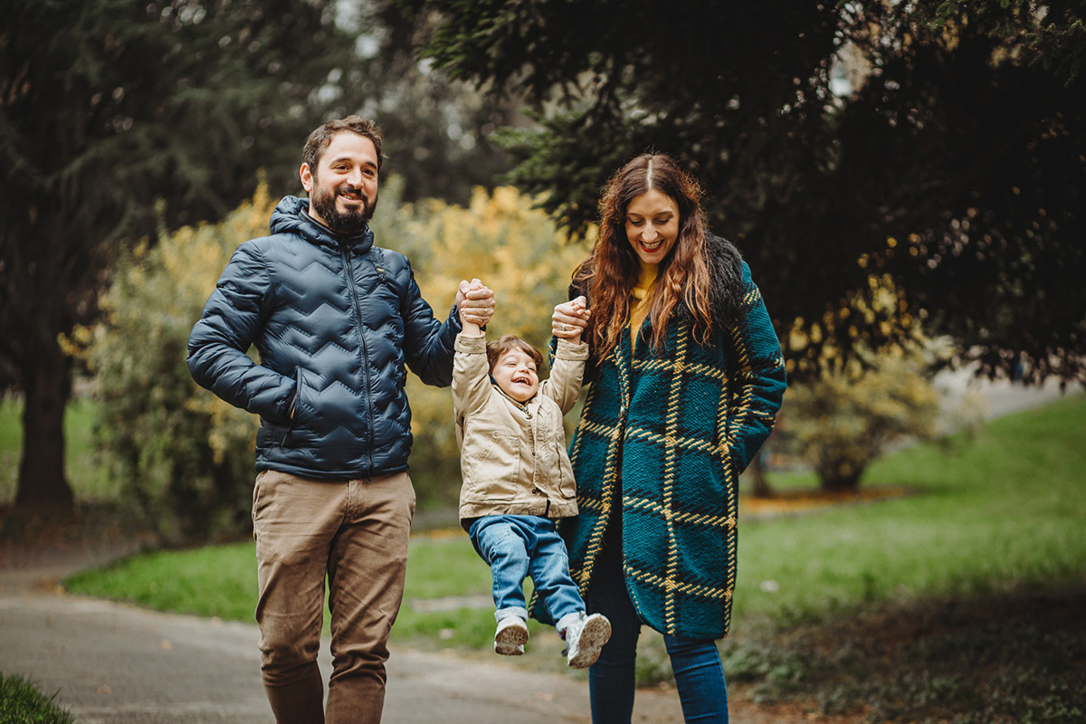 Parco del Valentino, fotografia di famiglia. Sessione fotografica autunnale. mamma e papà fanno volare il bambino