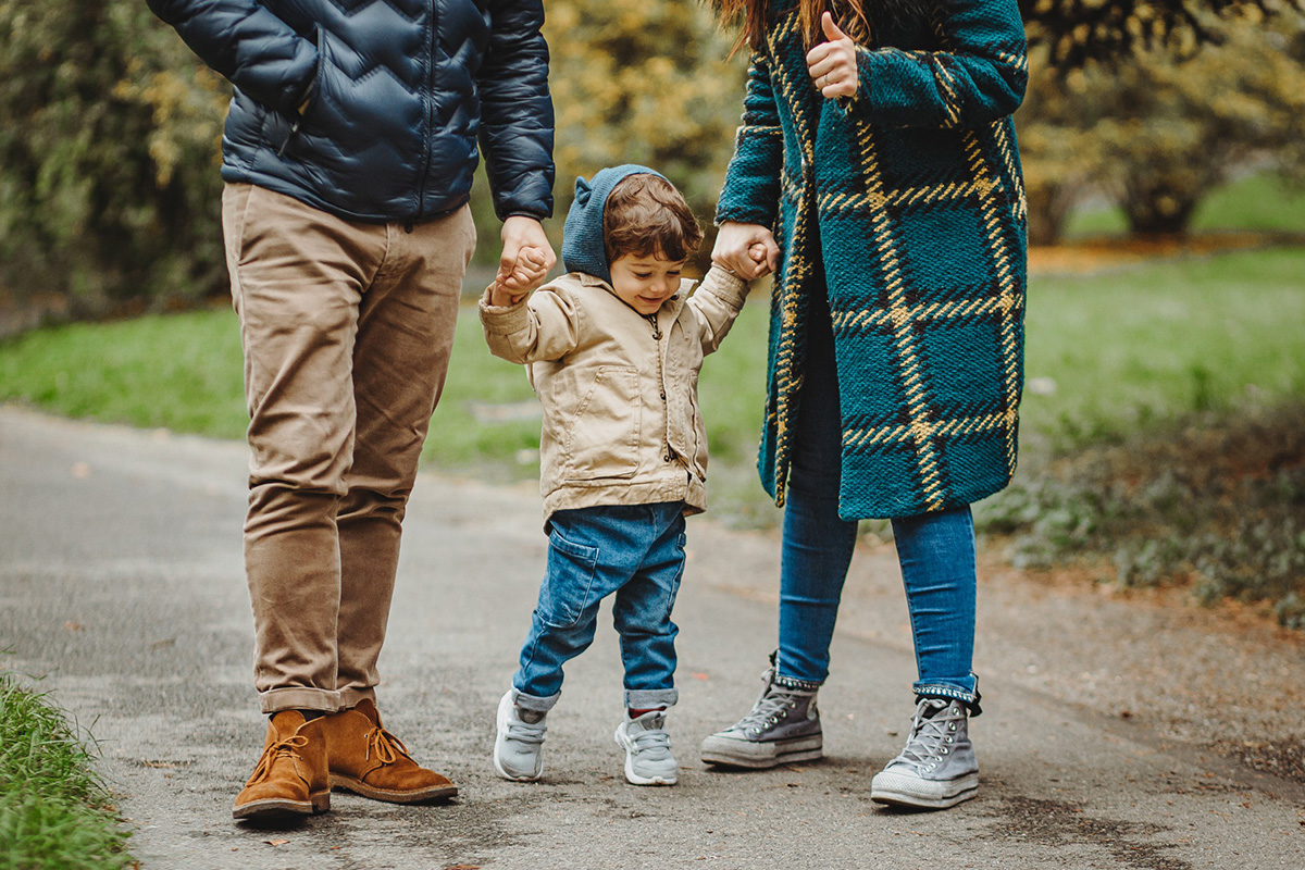 Parco del Valentino, fotografia di famiglia. Sessione fotografica autunnale. mamma e papà fanno volare il bambino