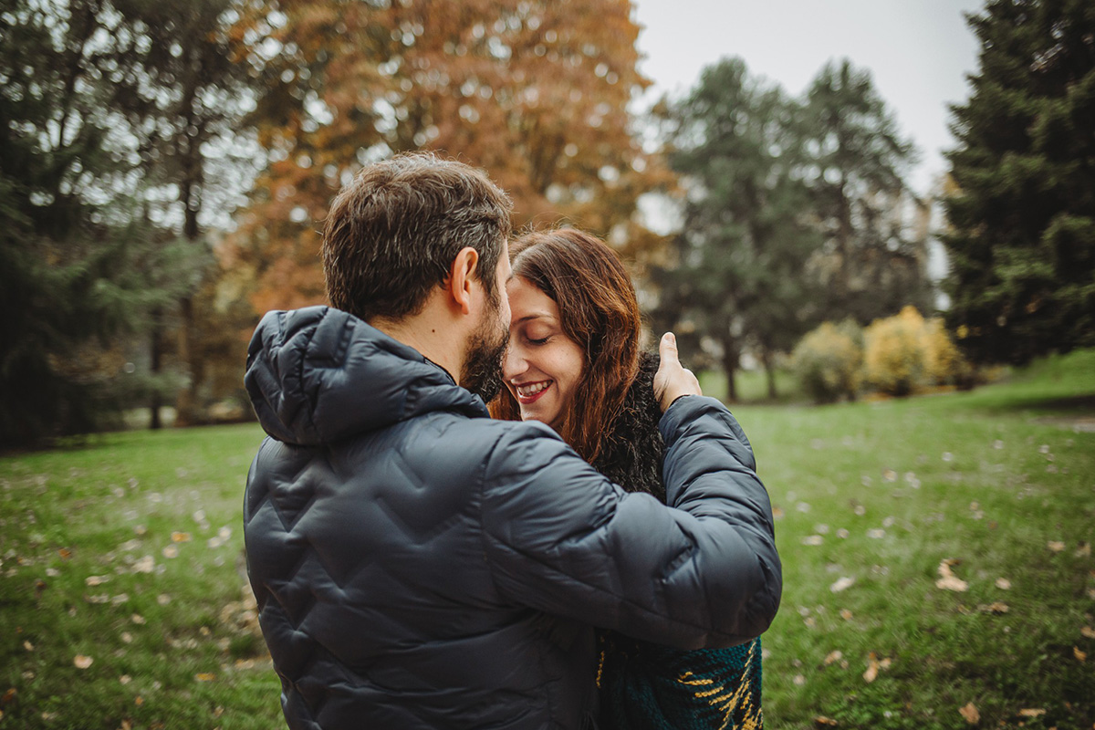 Parco del Valentino, fotografia di famiglia. Sessione fotografica autunnale. Papà bacia sulla fronte la mamma.