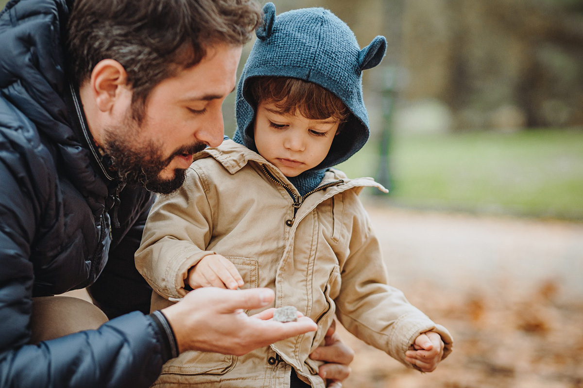 Parco del Valentino, fotografia di famiglia. Sessione fotografica autunnale. Papà da una foglia al bambino.