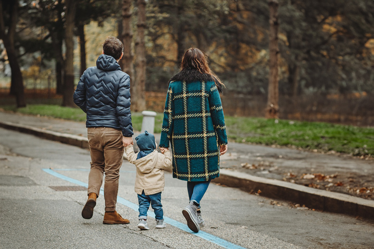 Parco del Valentino, fotografia di famiglia. Sessione fotografica autunnale sulla Fontana delle quattro stagioni. mamma papà e bambino camminano