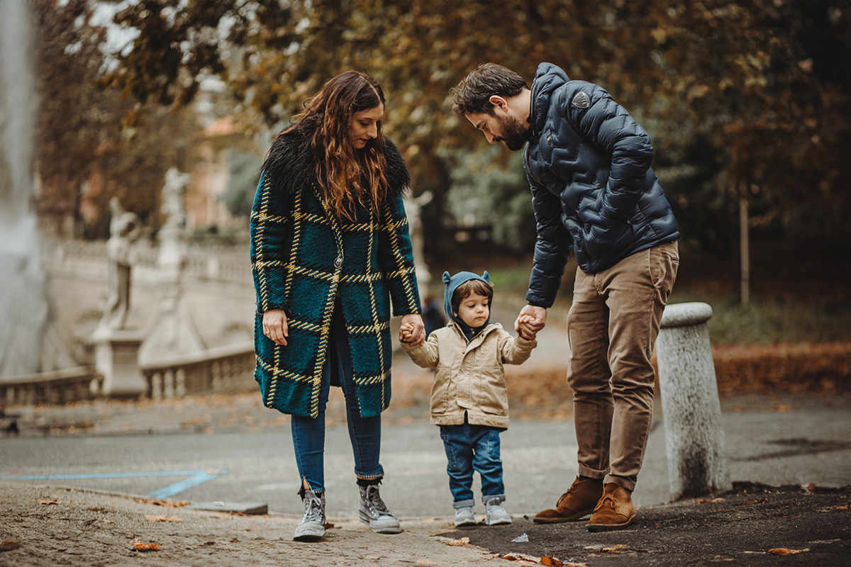 Parco del Valentino, fotografia di famiglia. Sessione fotografica autunnale sulla Fontana delle quattro stagioni. mamma papà e bambino camminano