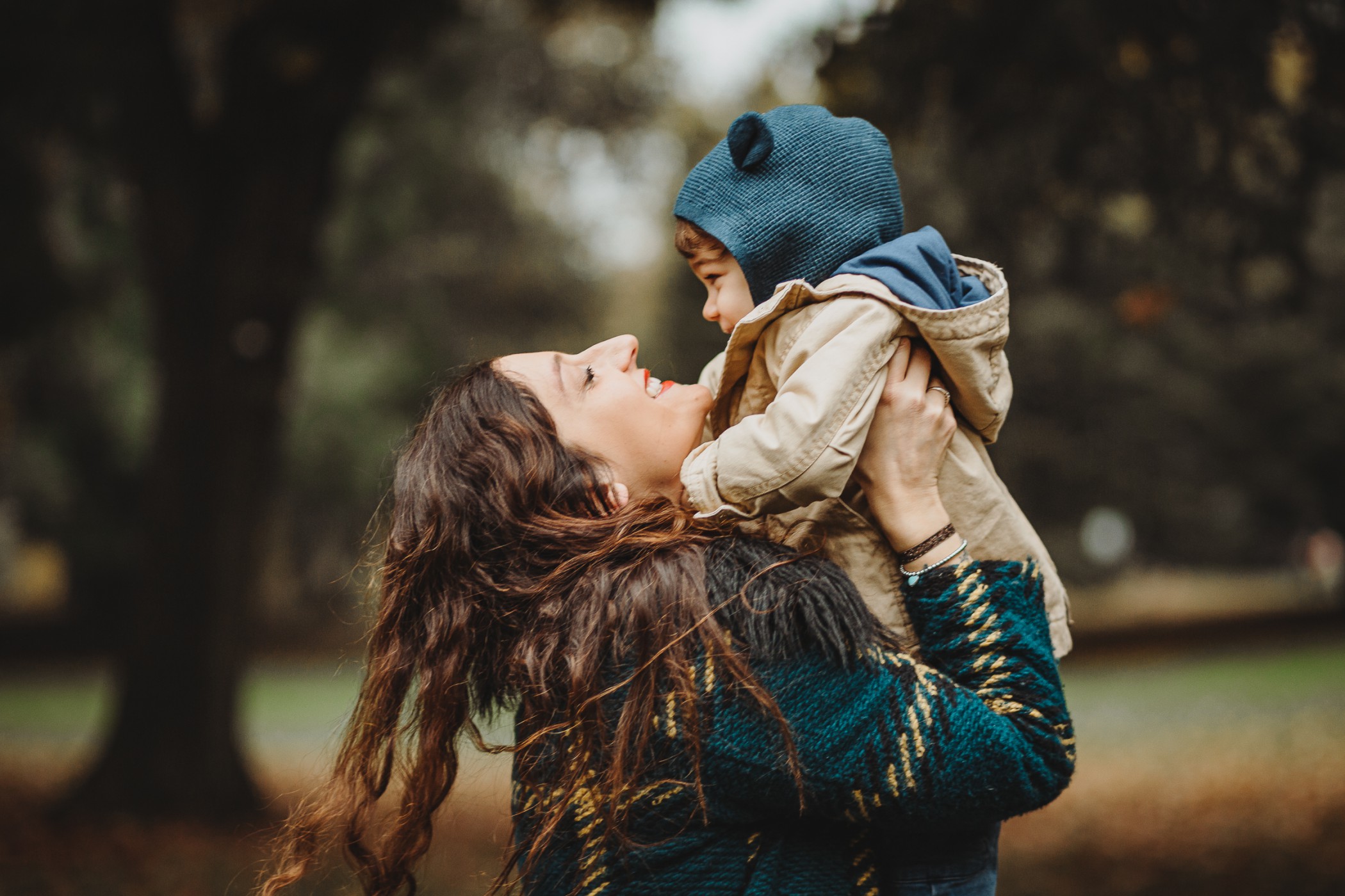 Parco del Valentino, fotografia di famiglia. Sessione fotografica autunnale. mamma prnde in braccio il bambino.