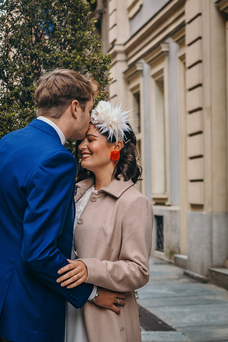 The number 6, Torino, editorial wedding. Sessione di coppia per le vie del centro di Torino.Sposo bacia la sposa sulla fronte