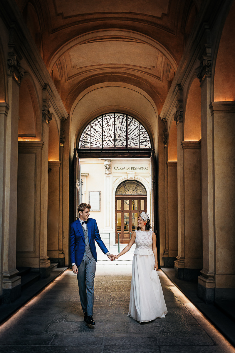 The number 6, Torino, editorial wedding. Sessione di coppia per le vie del centro di Torino.Sposi che entrano nel palazzo.