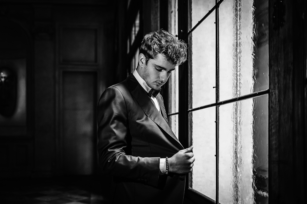 The number 6, Torino, editorial wedding. Preparazione dello sposo.Ritratto dello sposo alla finestra. Bianco e nero.