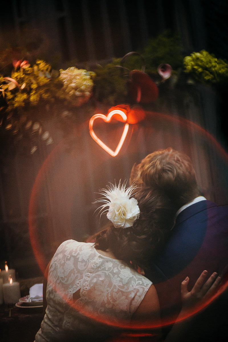 The number 6, Torino, editorial wedding. Ritratto degli sposi con i fiori e i cuori luminosi a tavola