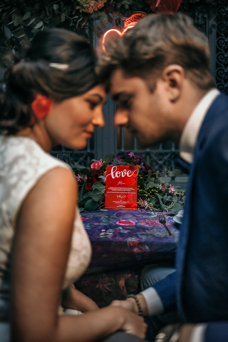 The number 6, Torino, editorial wedding. Sposi a tavola fronte fronte con l'invito di plexiglass rosso.