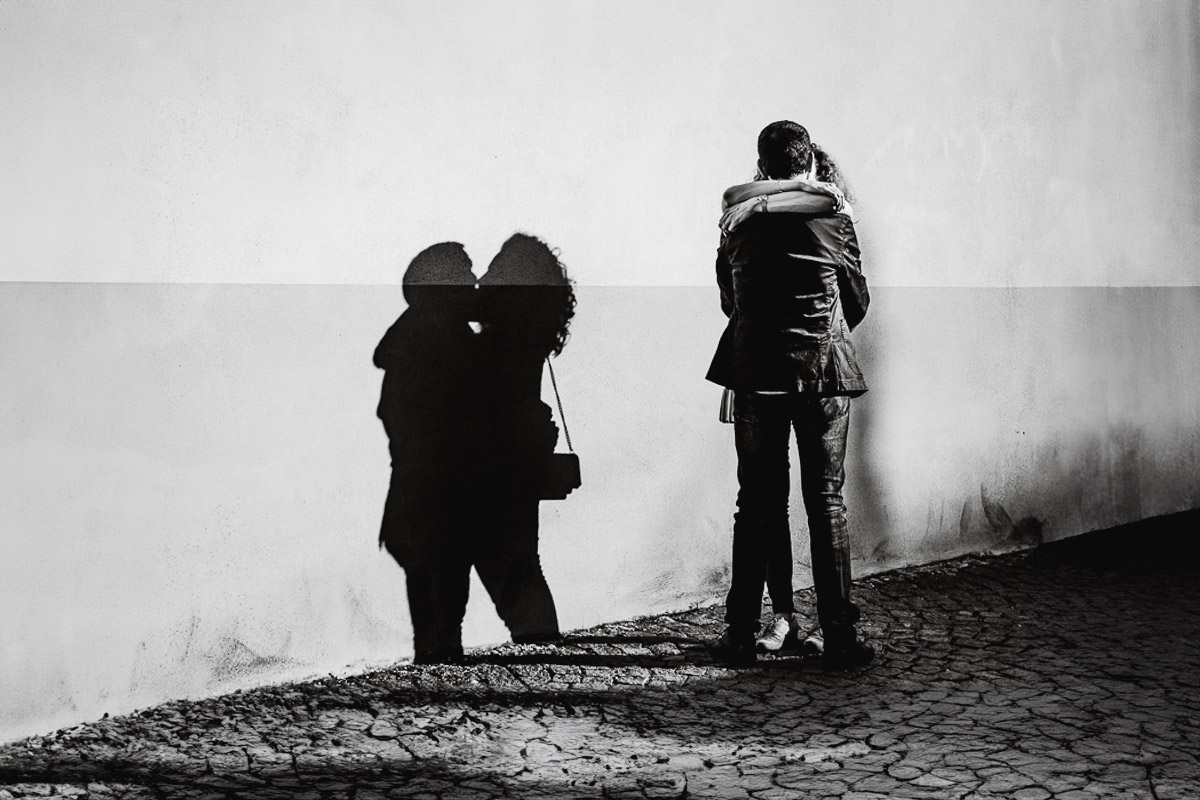 Prematrimoniale nel centro medievale di Chieri.Giulia e Domenico abbracciati. Ombra sul muro.