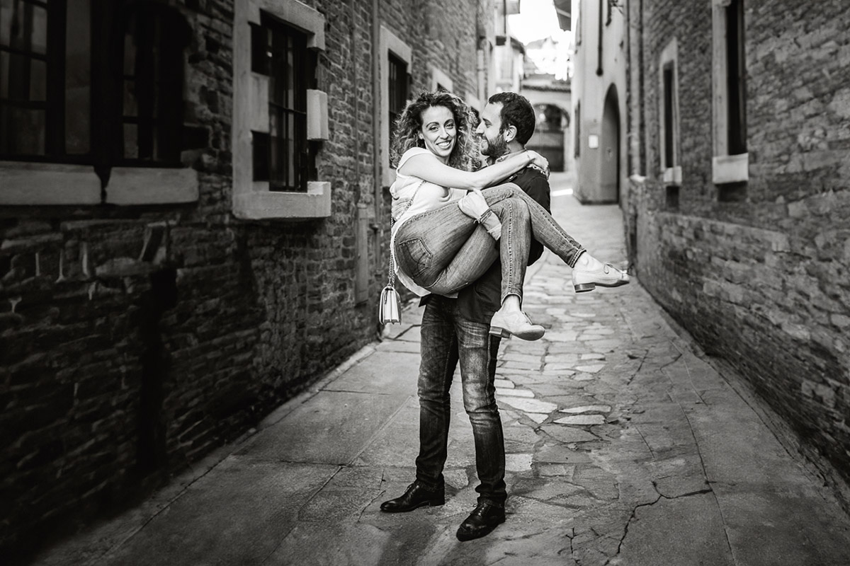 Prematrimoniale nel centro medievale di Chieri. Domenico prende in braccio Giulia. Bianco e nero.