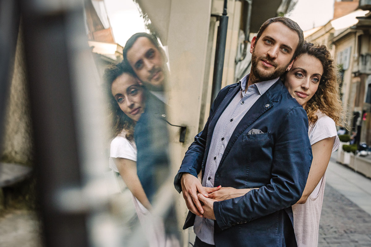 Prematrimoniale nel centro medievale di Chieri. Giulia e Domenico riflessi in un cartello a specchio.