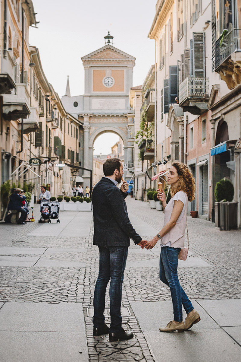 Prematrimoniale nel centro medievale di Chieri. Giulia e Domenico camminano mangiando un gelato davanti all'arco monumentale.